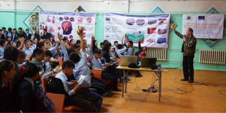 Children raise their hands in response to the project team’s questions.