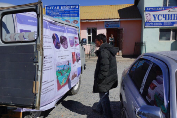 A miner studies the posters hung from the van.