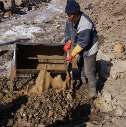 A miner works to extract gold from the rough terrain.