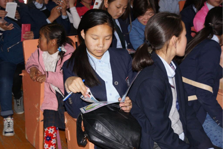 Boys and girls study the mercury awareness materials carefully.