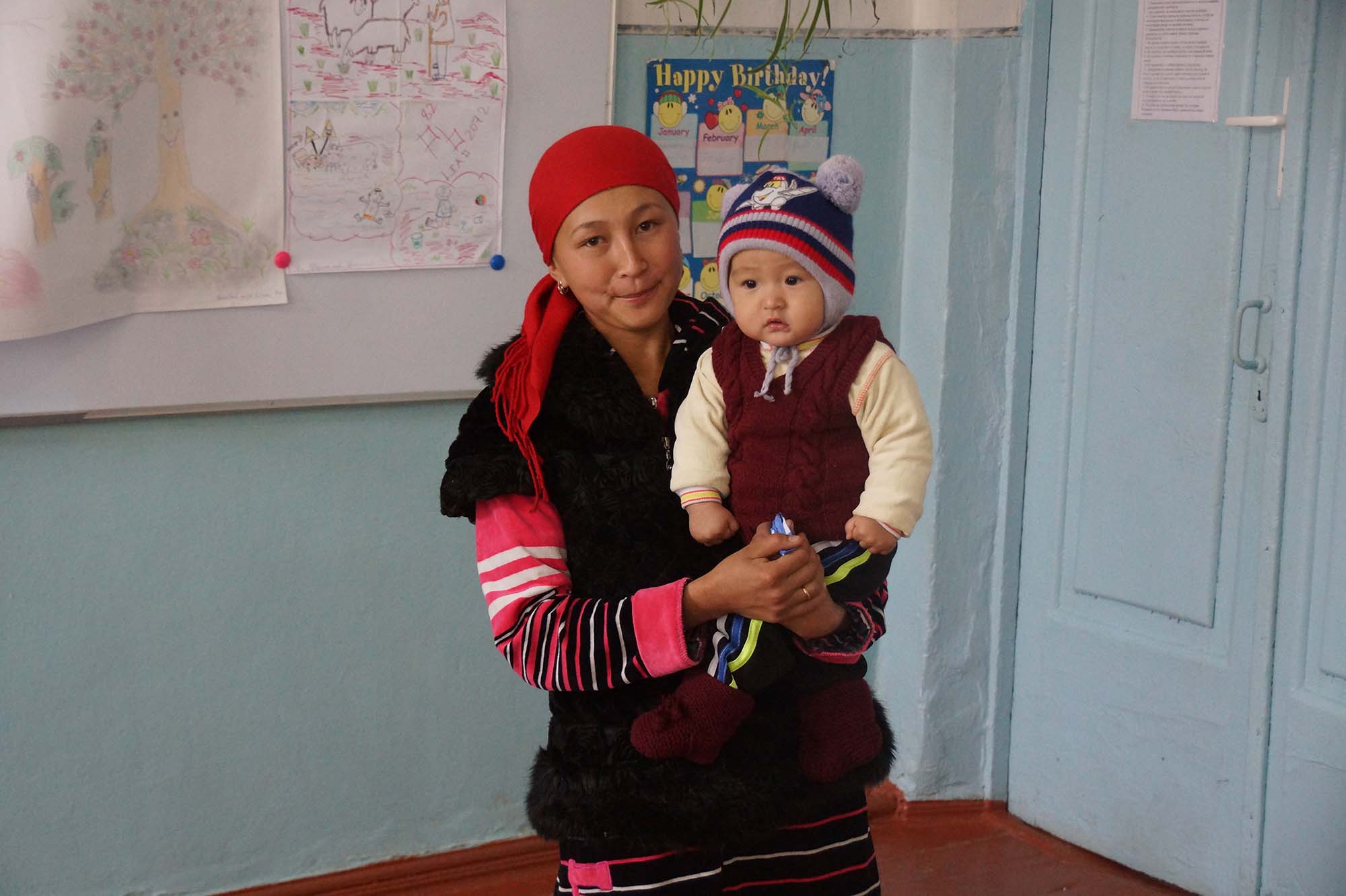 Mother and child at a school in Kyrgyzstan to watch an educational play teaching about the dangers of lead.