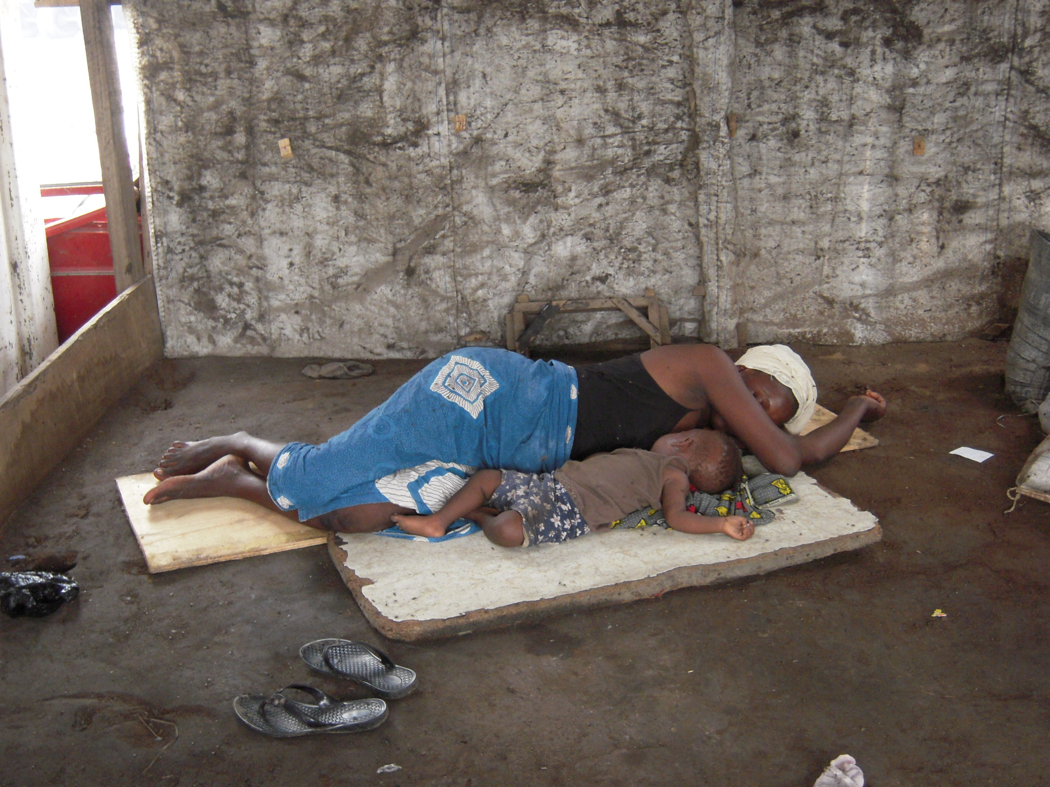 Mother sleeping with her child in the middle of Ghana's Agbogbloshie market, where most of the world's e-waste ends up. 