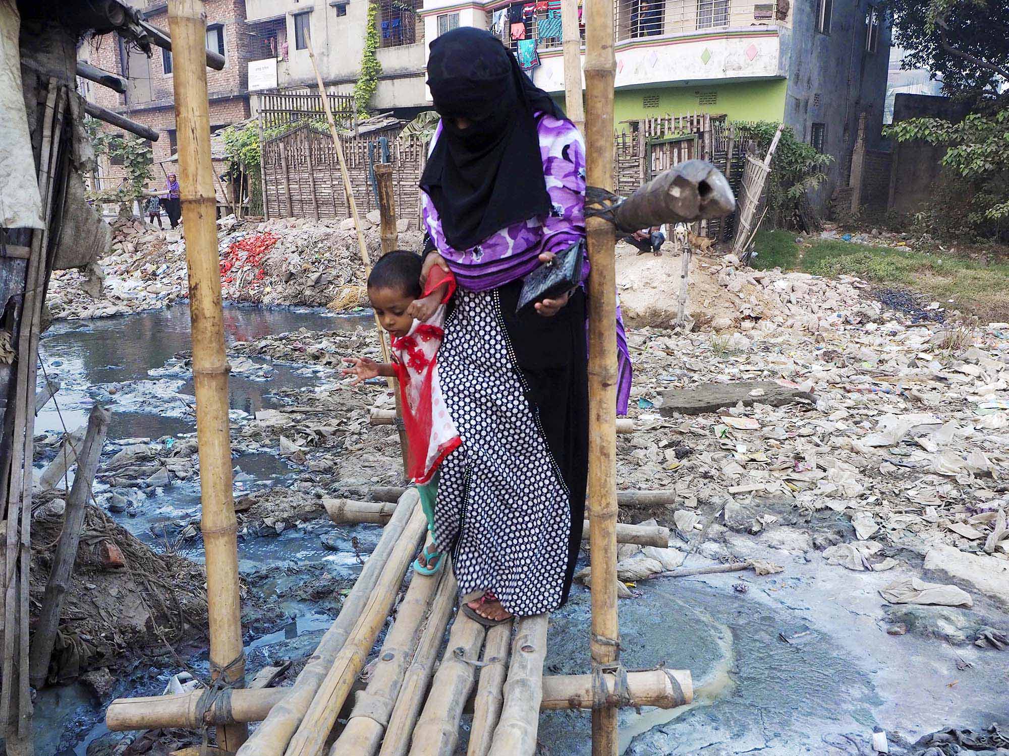 Residents of Hazaribagh, the tanning district in Dacha, make their way over a shaky bamboo bridge that spans a effluent canal carrying factory wast toward the Buriganga River. April 21st marks the third anniversary of the implosion of Bangladesh’s Rana Plaza garment factory complex,a tragedy that killed 1,129 and injured 2500 more young people sewing clothes for brands like Benetton, the Children’s Place and Wal-Mart. Rana Plaza illustrated how Bangladesh’s cheap prices came along with the country’s weak institutions, politically connected factory owners and a culture of impunity. But not every example of this impunity plays as well on TV. In 2012, Human Rights Watch’s “Toxic Tanneries,” revealed that none of the more than 250 leather tanneries in Old Dhaka’s Hazaribagh neighborhood treated the blue chromium-laced liquid that they used to transform rigid animal skins to into our supple leather. Even by the lax environmental standards of neighboring India, Hazaribagh is a disaster. In India, leather tanneries consistently flout pollution norms; in Bangladesh, they don’t even bother to try. In 2013, the same year as Rana Plaza, Hazaribagh made Pure Earth’s Worst Polluted List. In Hazaribagh, pollution is inescapable. Brown and grey liquid waste flows through a series of channels that criss-cross the neighborhood, carrying tannery waste into local creek with viscous water the color of liquid cement, choked with refuse, that oozes through the center of the neighborhood. One one side of the creek, stray dogs lounge on three foot piles of leather scraps. On the other side, you can glimpse the remnants of a glue factory that cook down various animal parts to make glue. The smell, equal parts chemicals, slaughterhouse and desperation, assaults you. This caustic blue-grey waste flows directly into the Buriganga River, where chromium and lead exceed permissible levels by 105 and 80 times, respectively. An estimated 180, 000 people in the area now suf