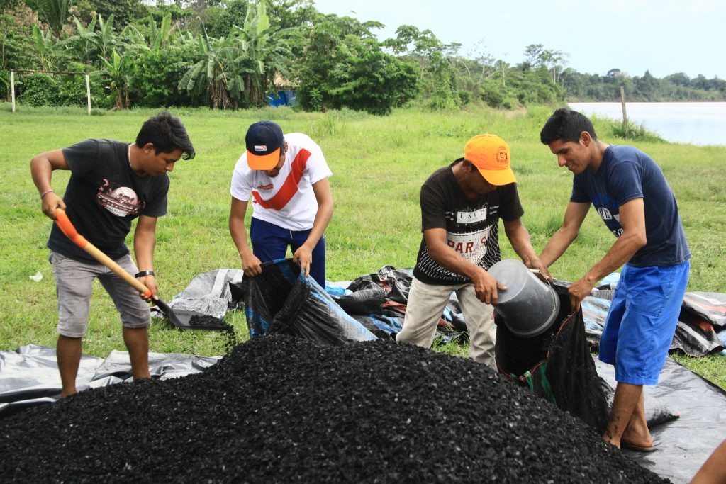 Rainforest reforestation - The team loads sacks with biochar, which is added to the seedlings as a soil amendment. 