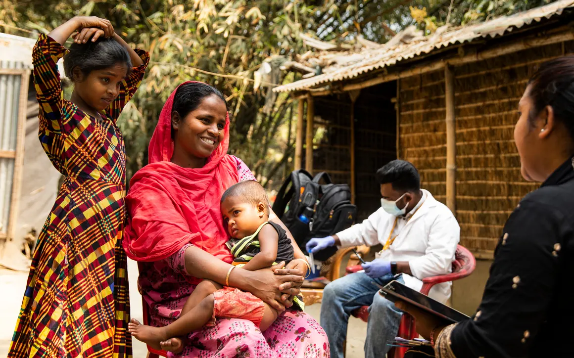 A health worker tests a child’s blood lead level during a community education session in Bangladesh.