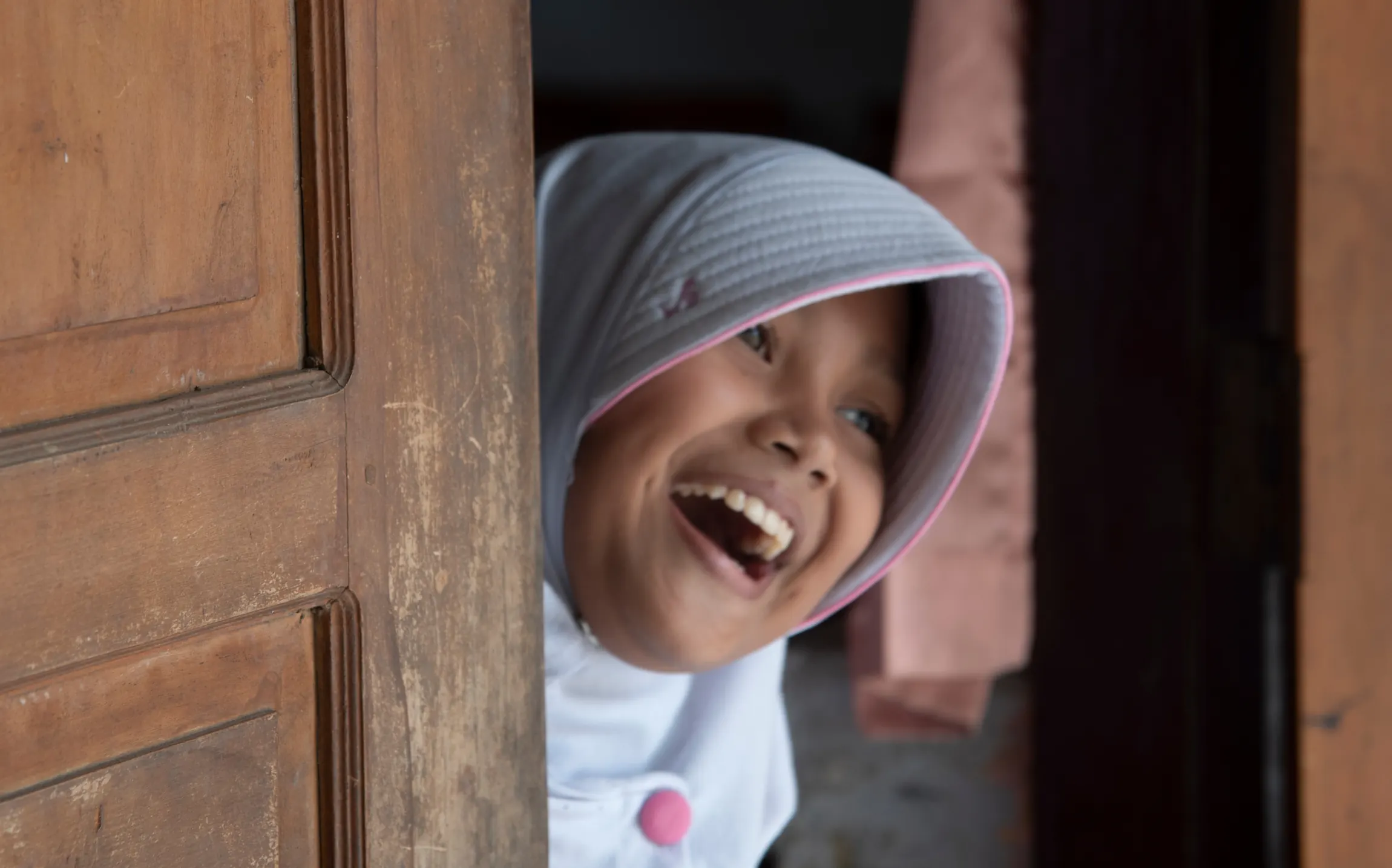 A schoolgirl smiles in Pesarean Village, Indonesia, where the Tegal Regency government now funds its own cleanup of lead-contaminated land.